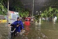 Warga mendorong sepeda motor yang mogok akibat banjir di Kota Semarang, Jawa Tengah. (Dok. BPBD Kota Semarang)