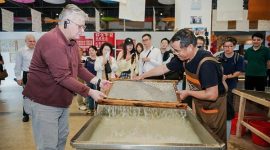 H.E. Mr. Karlis Eihenbaums，ambassador of Latvia to China, tries his hand at the traditional craft of Xuan papermaking.